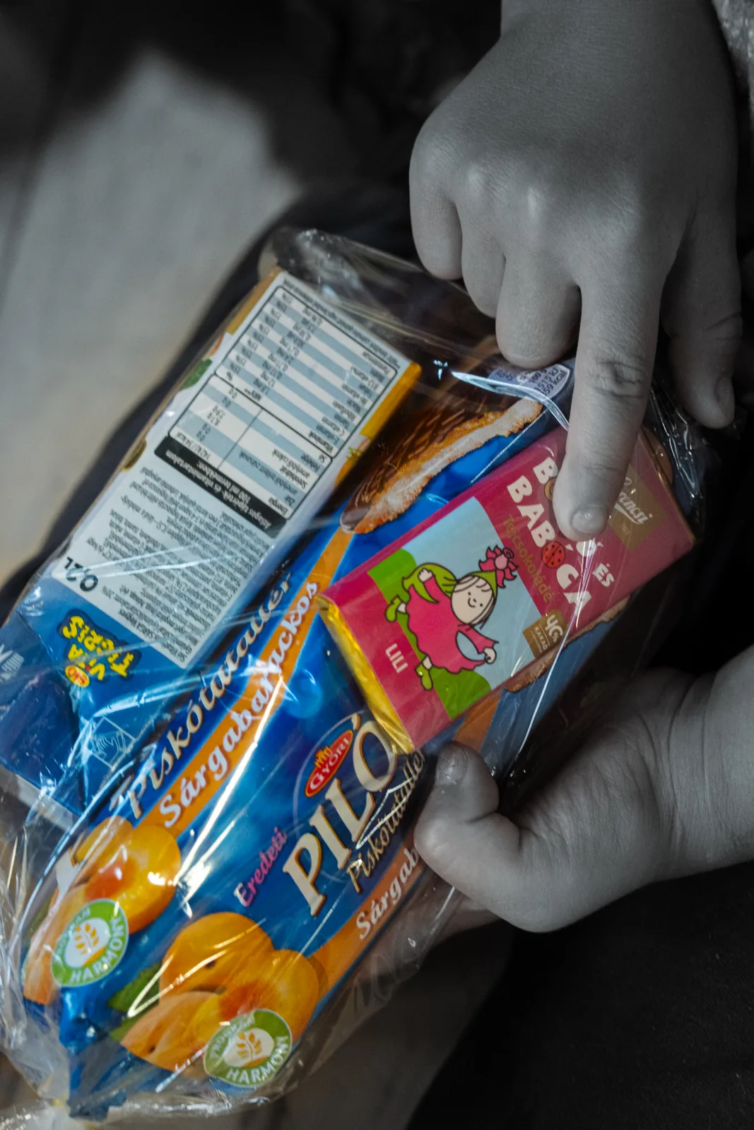 Hands holding a packet of treats in a black-and-white photograph