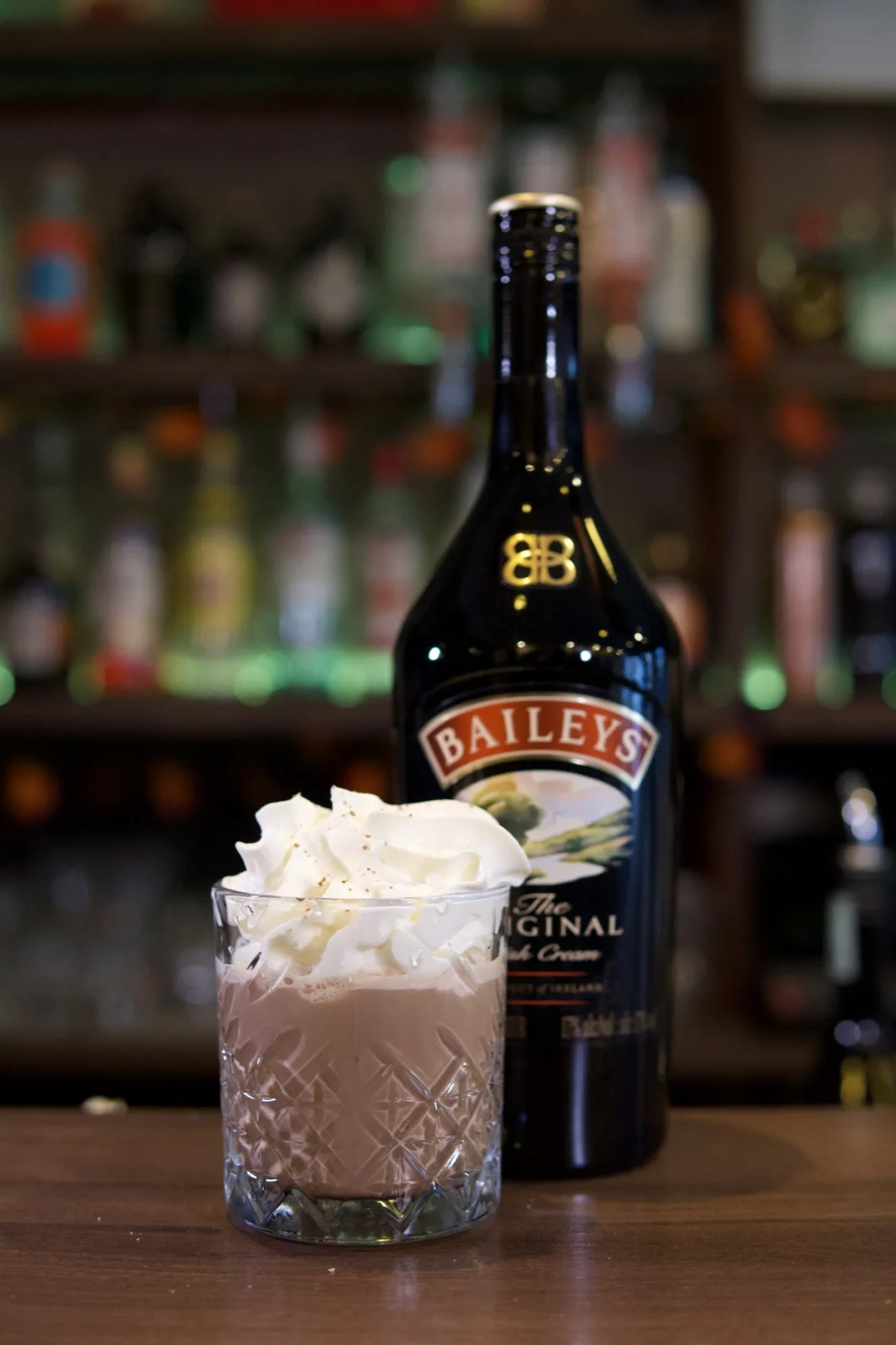 A cream-topped drink beside a bottle on the Úri Muri bar